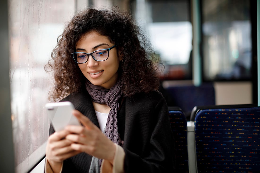 happy-woman-on-bus-smartphone