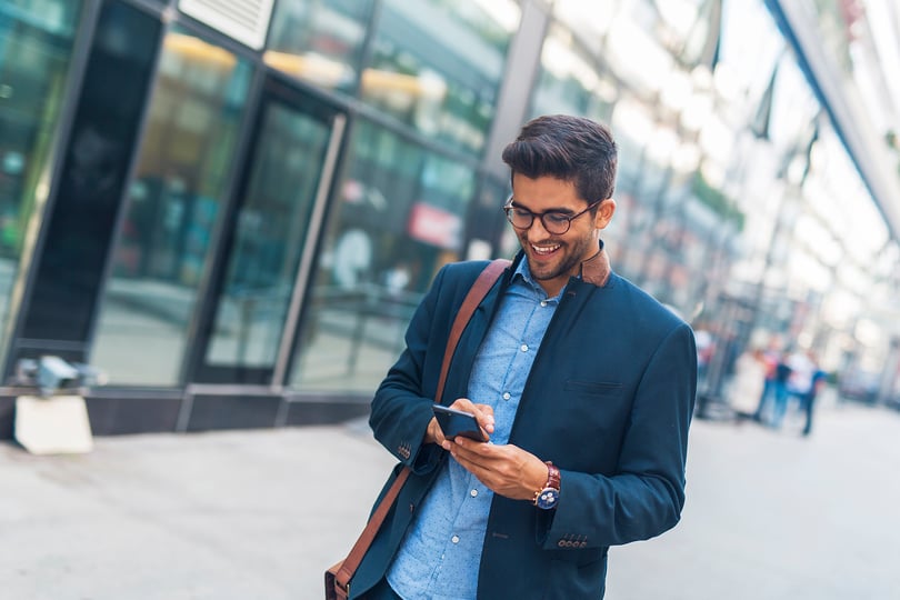 Man using his cellphone outside an office building